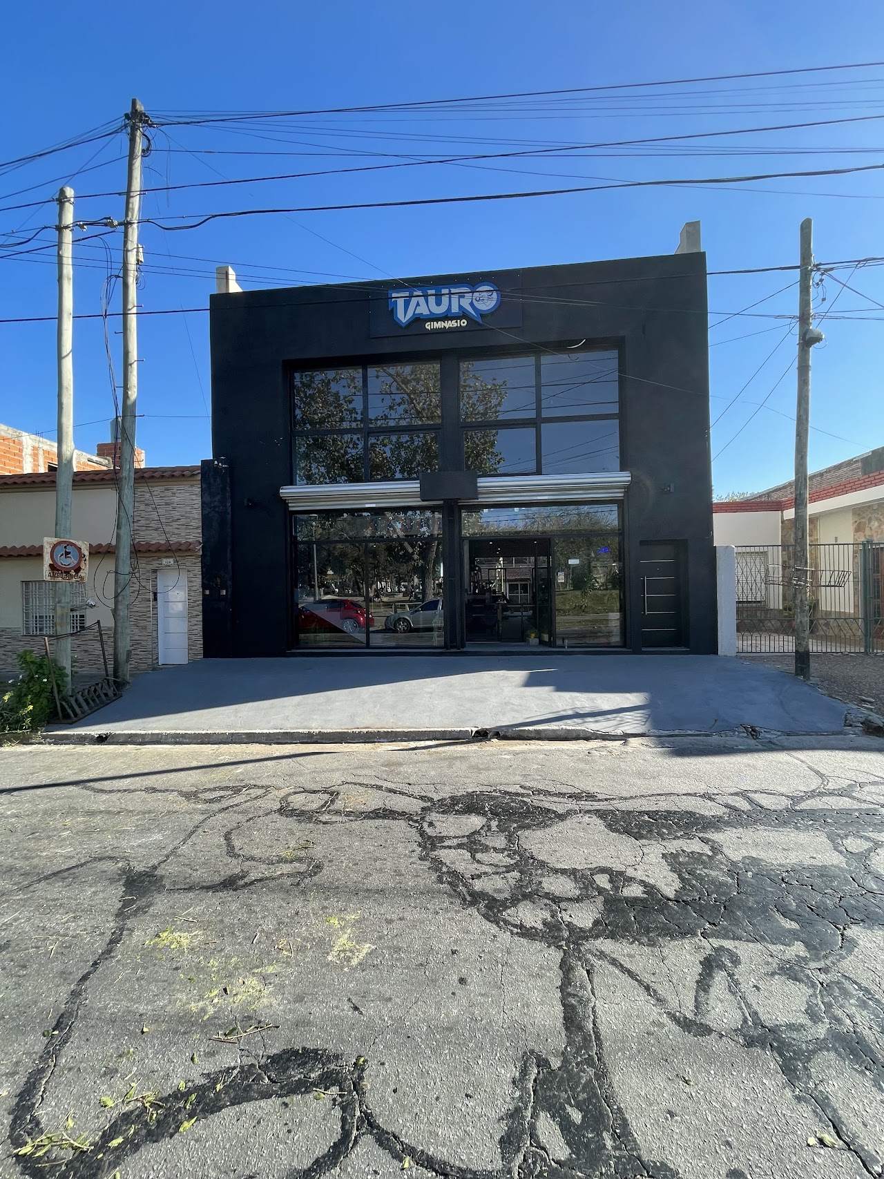Fachada exterior de Gimnasio Tauro Berazategui iluminada con neón azul